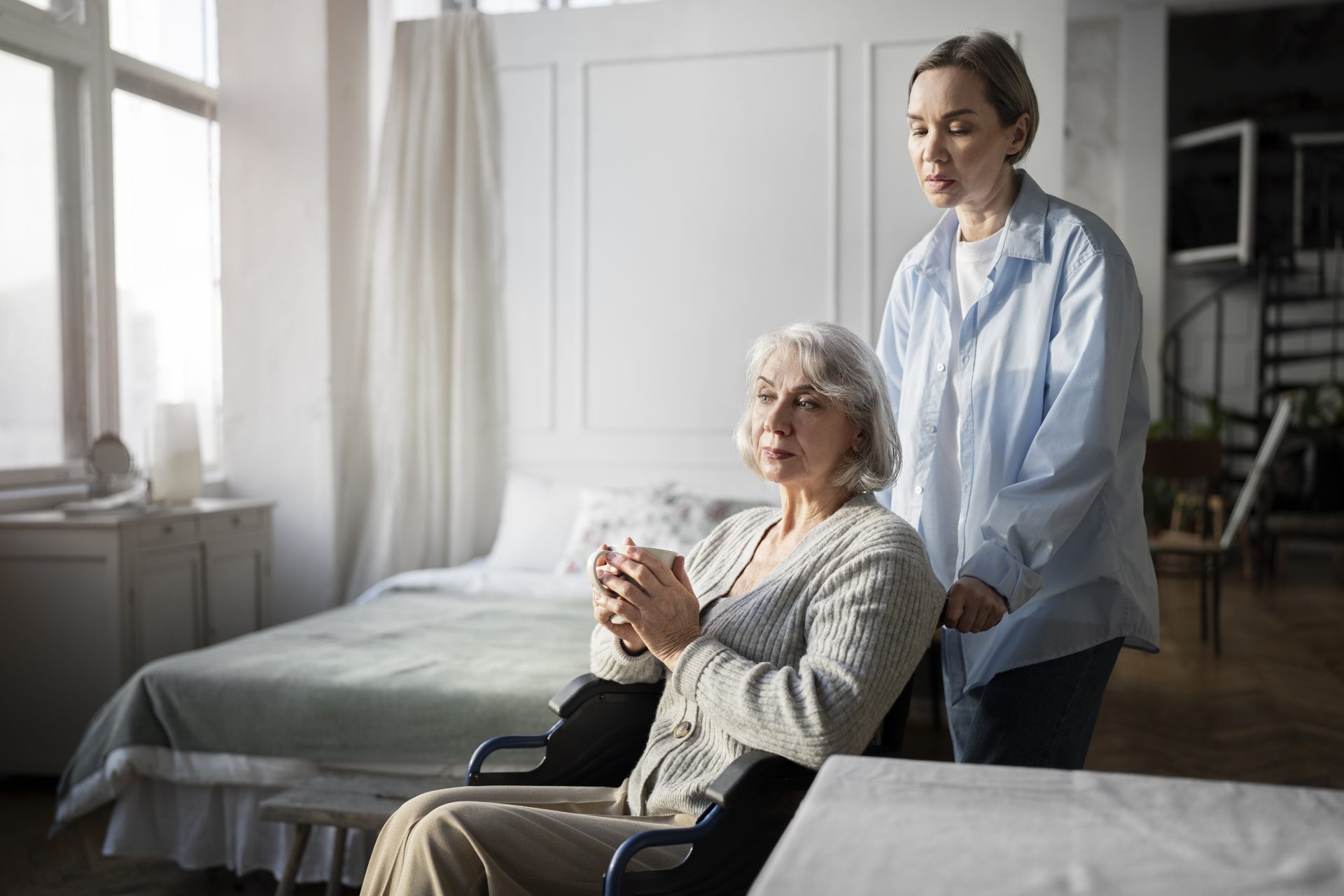 woman standing next to woman riding wheelchair